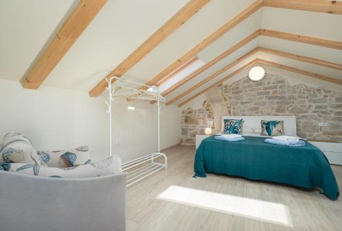 a attic bedroom with a bed and a chair at La casa di Cristina - apartments with sea view! in Vrsar