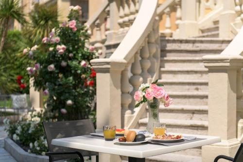 a table with a plate of food and flowers on it at Villa Italia Luxury Suites and Apartments in Arco