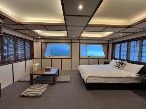 RuifangにあるShanhai Guan B&Bのベッド、テーブル、窓が備わる客室です。