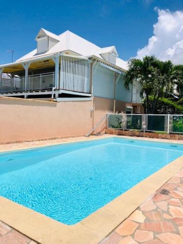 une grande piscine bleue devant une maison dans l'établissement Superbe Duplex résidence privée et piscine, à La Celle-sous-Gouzon