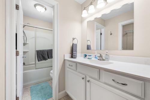 Baño blanco con lavabo y espejo en Niceville Dream Home Sleeps 13 en Niceville