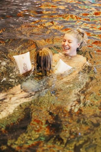a girl in the water with a book and a pig at Hotel Steiner Superior in Obertauern