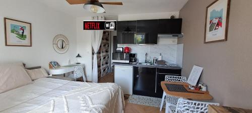 Cet appartement comprend une chambre avec un lit et une cuisine équipée d'un ordinateur portable. dans l'établissement Darmaillacq Studio avec Balcon, parking, Netflix, à Cholet