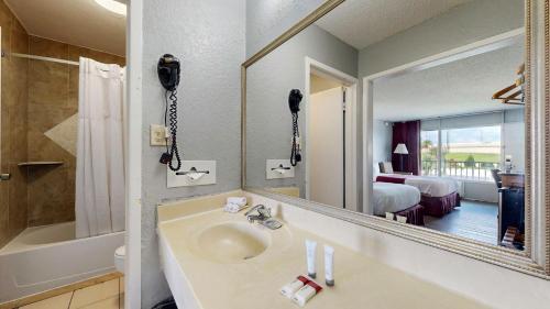 a bathroom with a sink and a mirror at Days Inn by Wyndham Orlando Downtown in Orlando