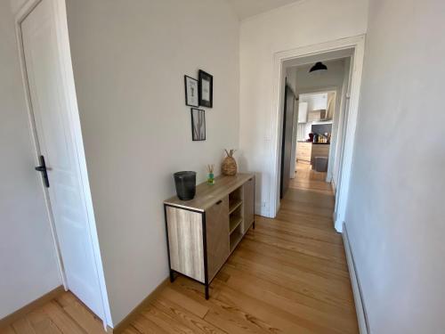 - un couloir avec une commode en bois dans l'établissement Le Carillon, centre ville proche gare, à Calais