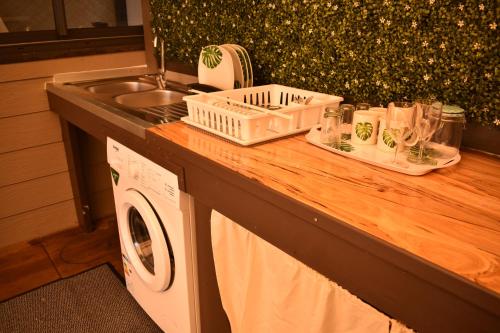 a kitchen counter with a sink and a washing machine at Fare O Mape in Faaa