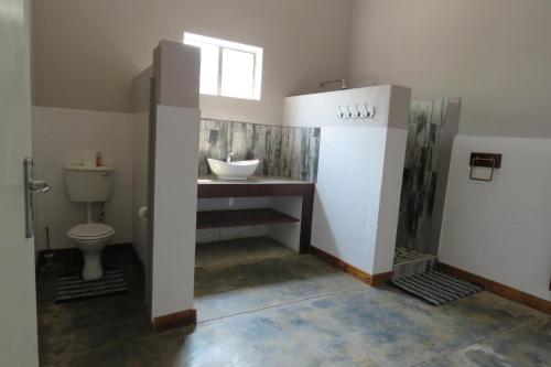 uma casa de banho com um lavatório e um WC em Faith City Guesthouse em Outjo