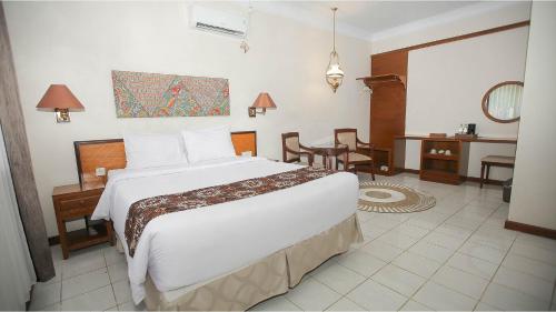 a hotel room with a large bed and a desk at Royal Brongto Hotel in Timuran