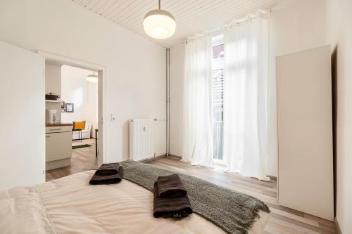 ein weißes Schlafzimmer mit einem großen Bett mit zwei Handtüchern darauf in der Unterkunft Exklusive Wohnung am Weserdeich in Bremen