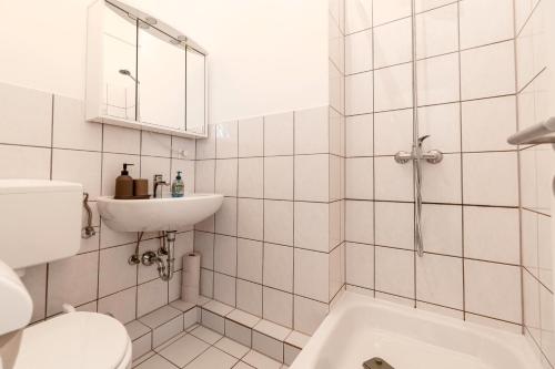 ein weißes Bad mit einem WC und einem Waschbecken in der Unterkunft Exklusive Wohnung am Weserdeich in Bremen