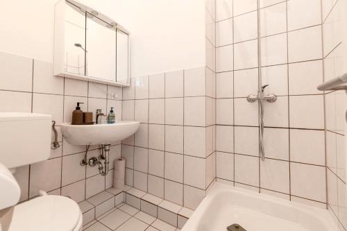 een witte badkamer met een toilet en een wastafel bij Exklusive Wohnung am Weserdeich in Bremen