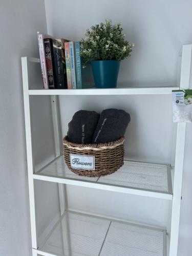 a book shelf with two baskets and a plant at House Of Nostalgia in Lumut