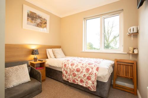 een slaapkamer met een bed, een bank en een raam bij Whitaker Lodge Bed & Breakfast in Castlepollard