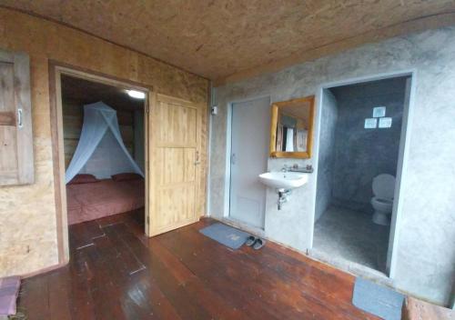 a bathroom with a bed and a sink in a room at Ban Oreo Homestay in Ban Pha Hu