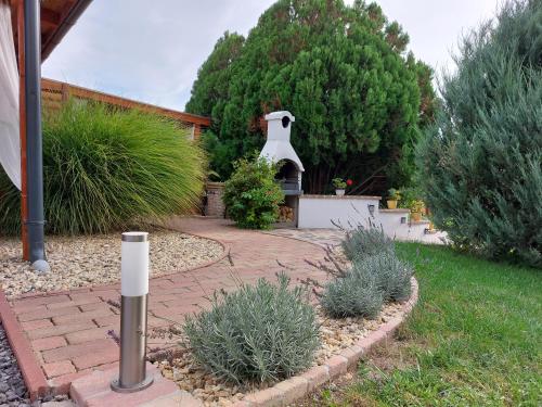 a garden with a brick patio with a fireplace at Tulipán Vendégház in Sárospatak
