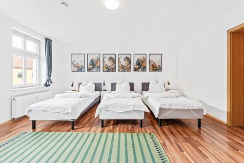 un grupo de camas en una habitación con alfombra en Cosy apartment with balcony and fireplace en Jüterbog