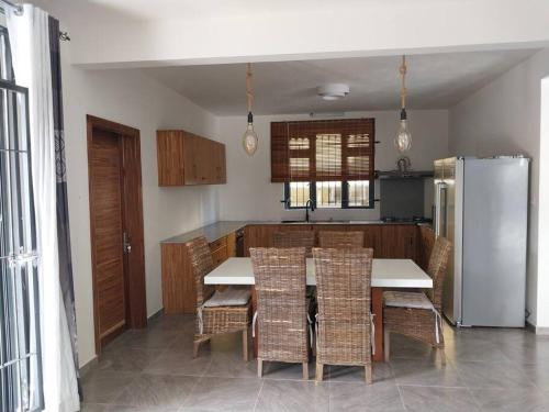 eine Küche mit einem Tisch und Stühlen sowie einem Kühlschrank in der Unterkunft Villa Deux Bras 