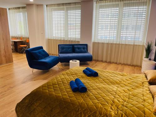 1 dormitorio con 1 cama con zapatillas azules en Apartmán Sitka, en Trenčín