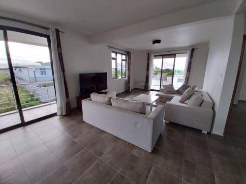 a large living room with two couches and a television at Villa Deux Bras in Deux Bras