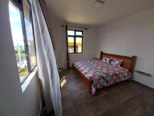 a bedroom with a bed and a window at Villa Deux Bras in Deux Bras