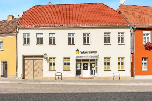 a white building with red roofs on a street at Cosy apartment with balcony and fireplace in Jüterbog