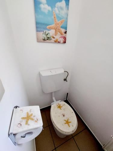 a bathroom with a toilet and a picture on the wall at Lexi Jakuzzis Apartman Balatonboglár in Balatonboglár