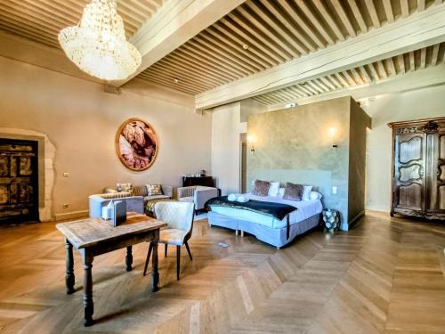 ein Schlafzimmer mit einem Bett, einem Sofa und einem Tisch in der Unterkunft Les Chambres De La Renaissance in Sainte-Julie