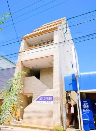 een gebouw met een bord aan de zijkant bij ゲストハウスシティ in Hitoyoshi