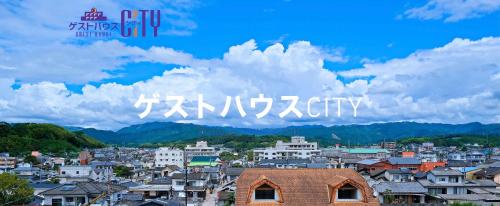 vistas a una ciudad con montañas en el fondo en ゲストハウスシティ, en Hitoyoshi