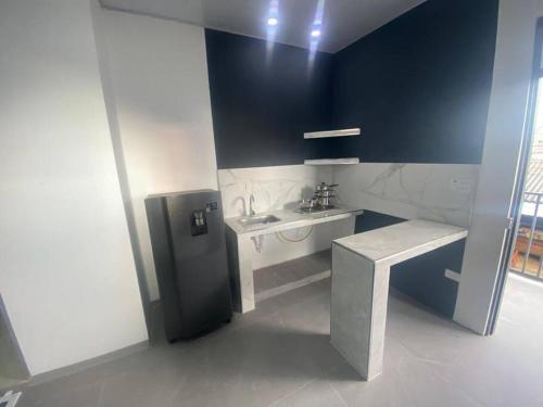 W łazience znajduje się czarna lodówka i umywalka. w obiekcie Apartestudios del Sol Montelibano w mieście Montelíbano