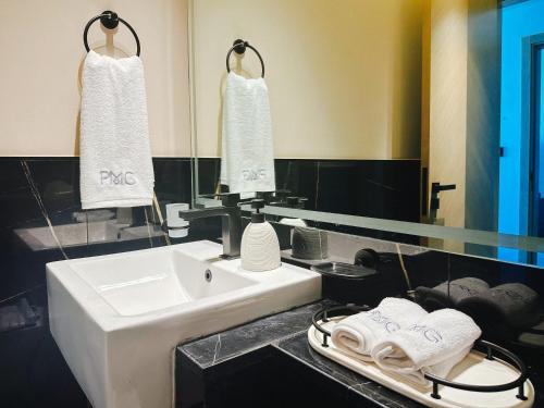 uma casa de banho com lavatório, espelho e toalhas em Waterfront apartment with Burj Khalifa views in Business Bay em Dubai