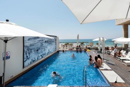 een zwembad in een hotel met mensen erin bij Grand Sea View Retreat by Sea N' Rent in Tel Aviv