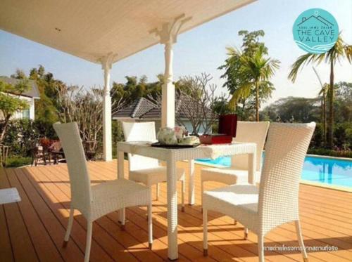 a white table and chairs on a deck with a pool at The Cave Valley เดอะเคฟว วัลเลย์ in Ban Chong (2)