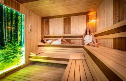 two people are sitting in a sauna at Apartmán Liptovsky Ján in Liptovský Ján