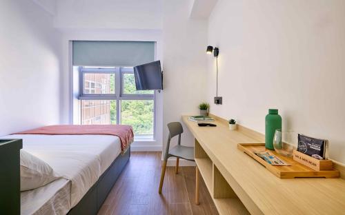 香港的住宿－South Nest，一间卧室配有一张桌子、一张床和一个窗户