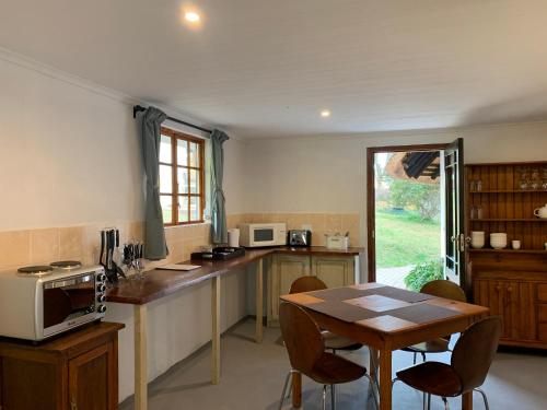 a kitchen with a table with a microwave and a table with chairs at Bramleigh Farm in Nottingham Road