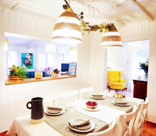 a dining room with a white table and white chairs at Casa Calina in Mauguio