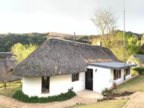 a small white house with a thatched roof at Bramleigh Farm in Nottingham Road
