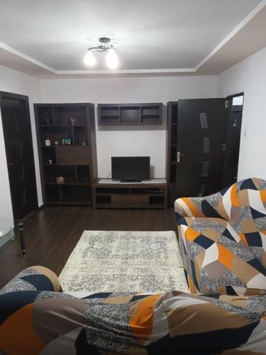 een woonkamer met een bank en een flatscreen-tv bij Teodora in Piteşti