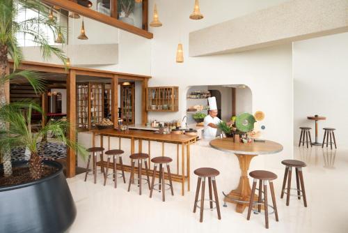 a restaurant with stools and a bar in a room at New World Hoiana Beach Resort in Hoi An