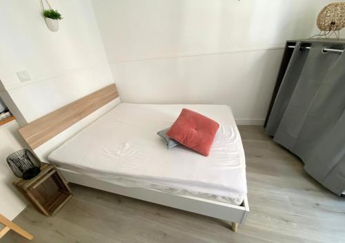 - un lit avec un oreiller rouge dans l'établissement Le Clain- Poitiers Cathédrale -La Conciergerie, à Poitiers