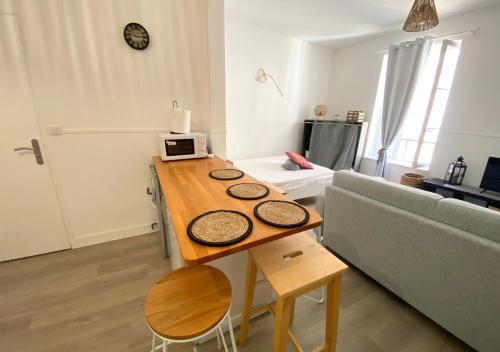 un salon avec une table et un canapé dans l'établissement Le Clain- Poitiers Cathédrale -La Conciergerie, à Poitiers