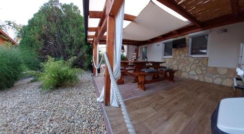 un patio al aire libre con una mesa de madera y un techo en Tulipán Vendégház, en Sárospatak