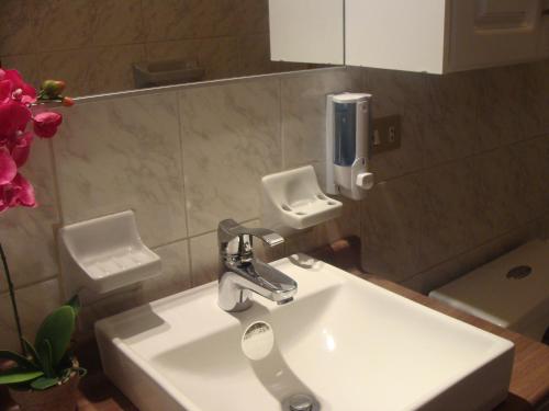 a bathroom with a sink and a soap dispenser on the wall at Hotel Sumaq Kay in Cumbayá