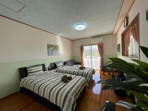 two beds in a room with green walls at NAGO Sakura Resort Inn - Vacation STAY 14448v in Nago