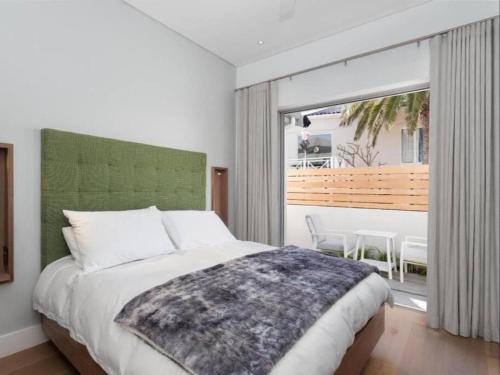 1 dormitorio con cama y ventana grande en Boulders Beach Villa, en Simonʼs Town