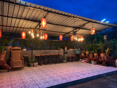 a patio with awning and tables and chairs and lights at Ban Sam Bai Thao 