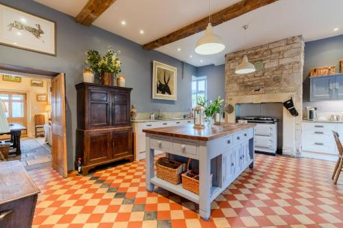 a large kitchen with blue walls and a checkered floor at Down Farm Manor in Stroud