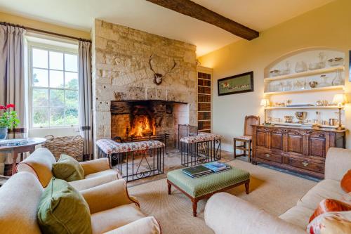 a living room with a large stone fireplace at Down Farm Manor in Stroud