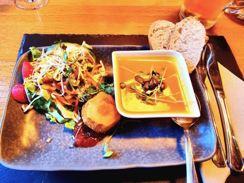 a plate of food with a salad and a bowl of soup at Altes Eishaus, Hotel & Restaurant in Gießen